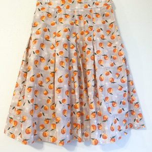 Spring Oranges Skirt -skirt with gray background and oranges pattern. Has pockets, and pleats. Fitted waistband. Zips closed at the left side