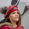 girl standing against a gray wall wearing a scarlet and gray tam with a grey pom pom