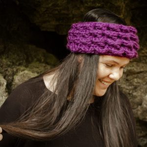 girl wearing a violet purple ear warmer or headband. The headband is hand crocheted in crocodile stitch.