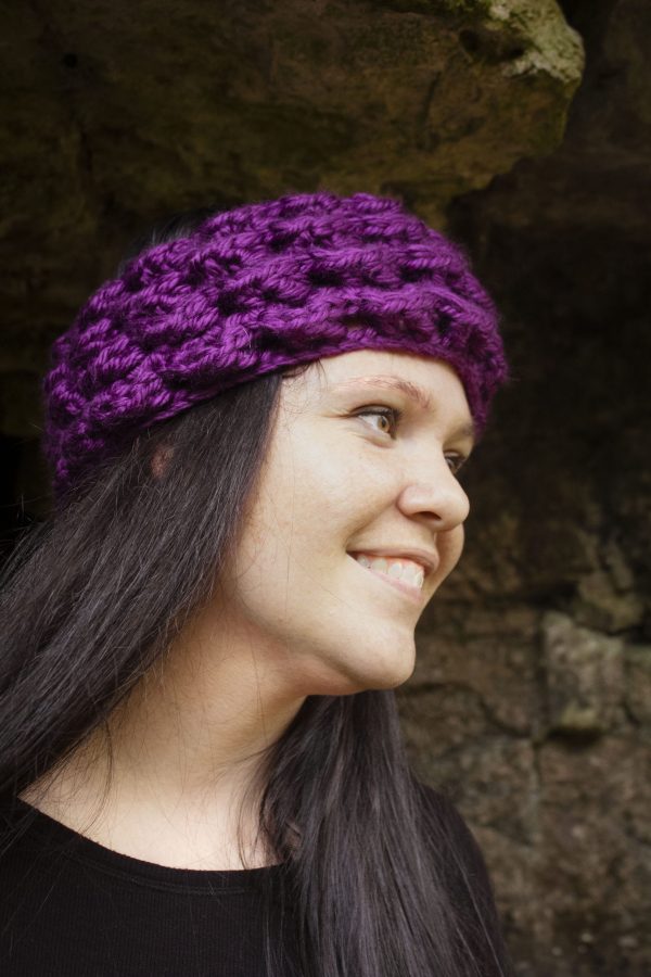 girl wearing a violet purple ear warmer or headband. The headband is hand crocheted in crocodile stitch.