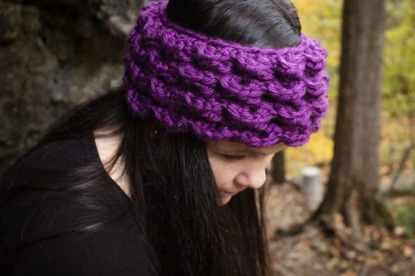 girl wearing a violet purple ear warmer or headband. The headband is hand crocheted in crocodile stitch.