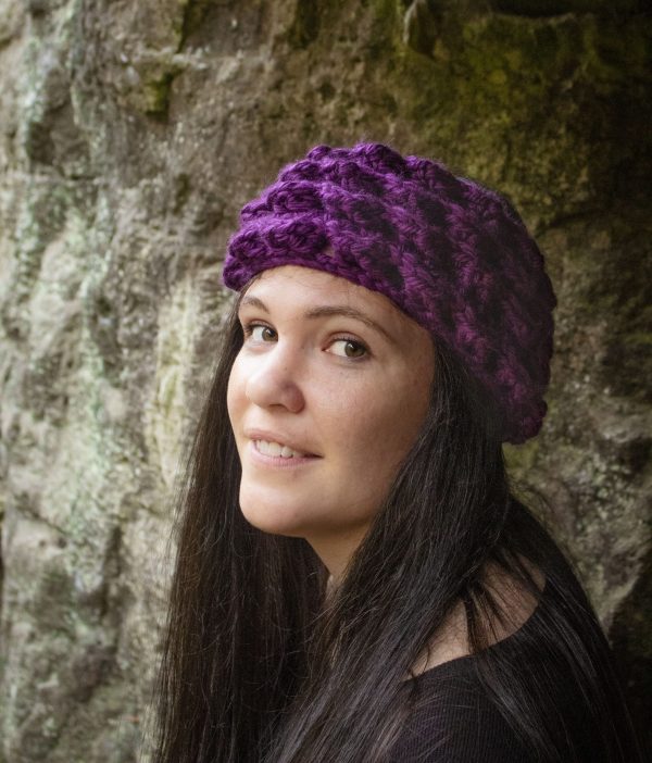 girl wearing a violet purple ear warmer or headband. The headband is hand crocheted in crocodile stitch.