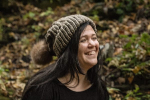 girl wearing taupe hand knit toboggan with tan pom pom