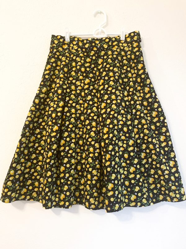 The Spring Lemons skirt is a Lemon pattern pleated skirt with black background. Has pockets and zipper closure. 30 1/2 inch waist. Length of skirt is 27 inches